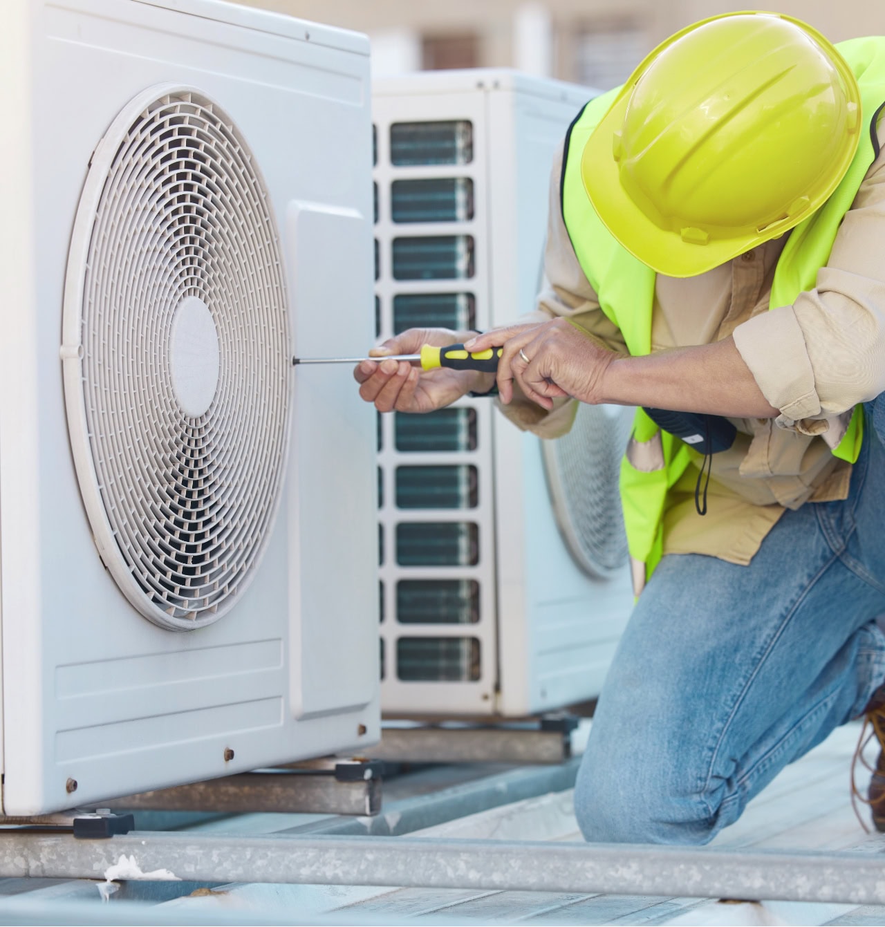 Technician performing HVAC maintenance on air conditioner in Springfield, Oregon.