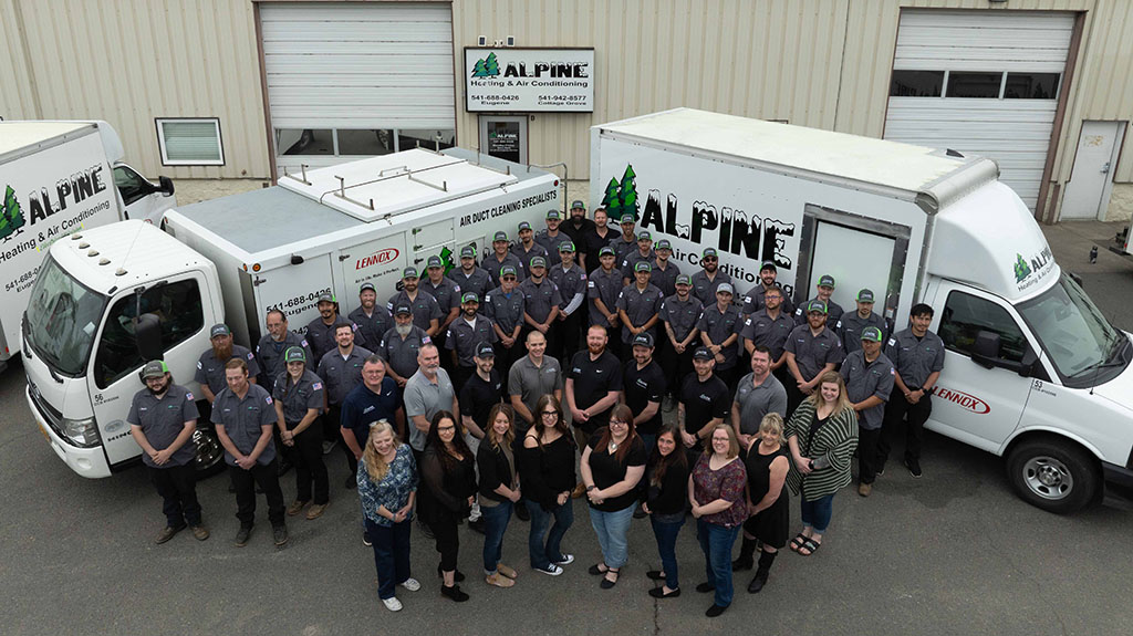 Alpine team in front of company trucks.