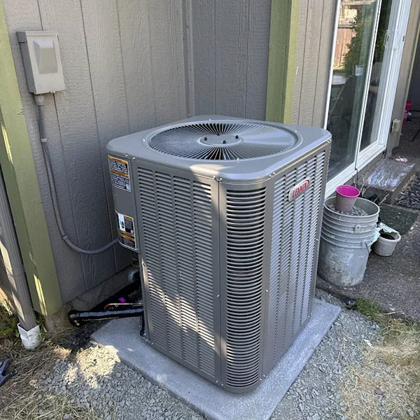 Air conditioning unit outside a grey home.