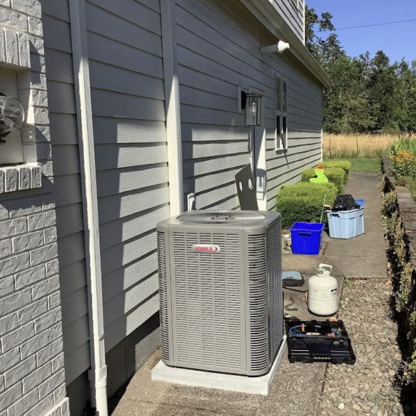 Lennox AC system outside a home with a technicians tools on the ground.
