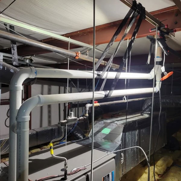 Air handlers and piping installed in an attic of a building.