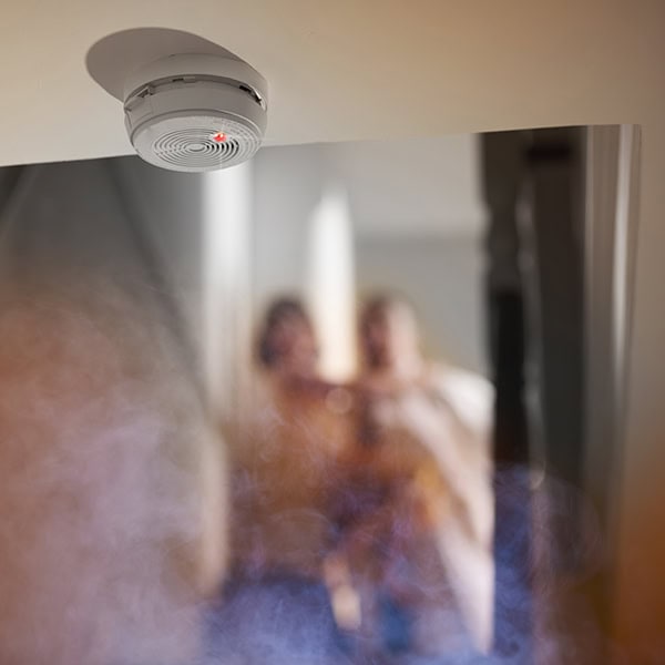 Smoke surrounding a smoke detector in a home.