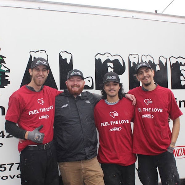 Four HVAC technicians standing in front of an Alpine branded work vehicle.