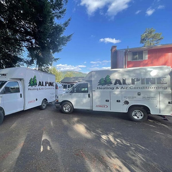 Two Alpine work vehicles in a business parking lot.