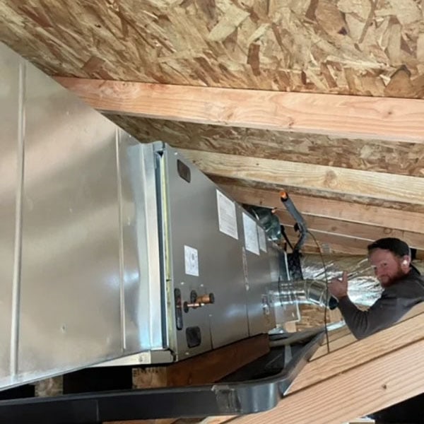 HVAC technician in the attic of a new building being built.