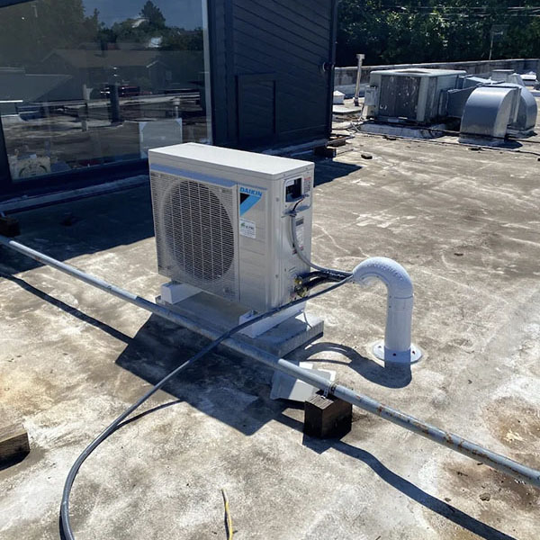 A Daikin heat pump on the roof of a business.