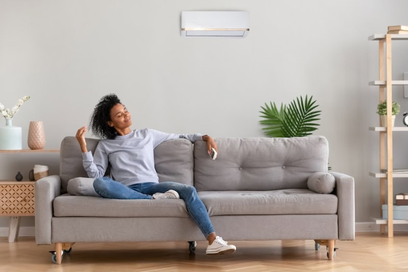 Woman in living room with a ductless system.