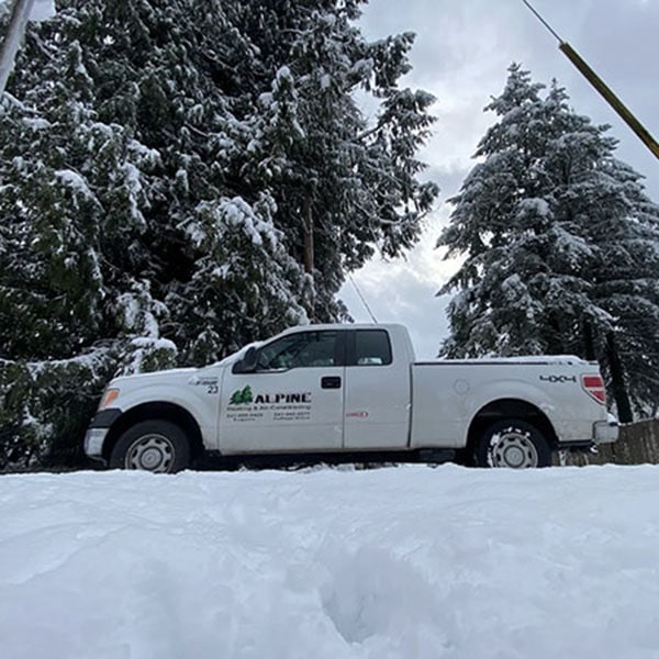 Alpine work vehicle parked on a snowy road.