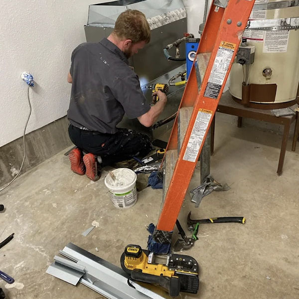 HVAC technician performing maintenance on a gas furnace.
