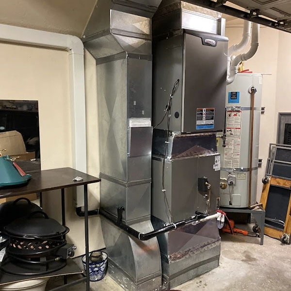 A gas furnace system in a homes garage.