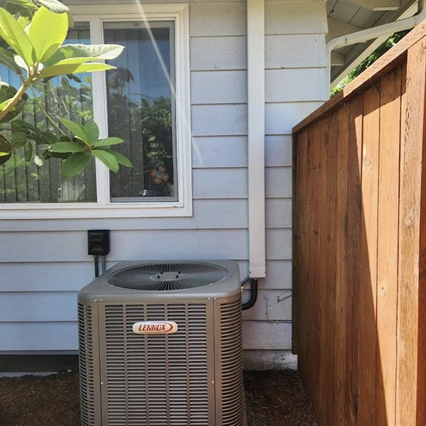 Lennox HVAC system outside a home in front of a window.