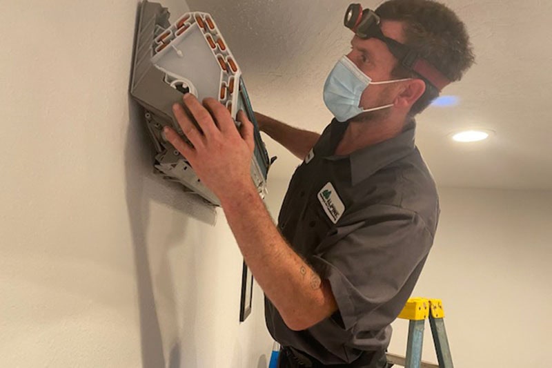 Alpine HVAC technician working on a d