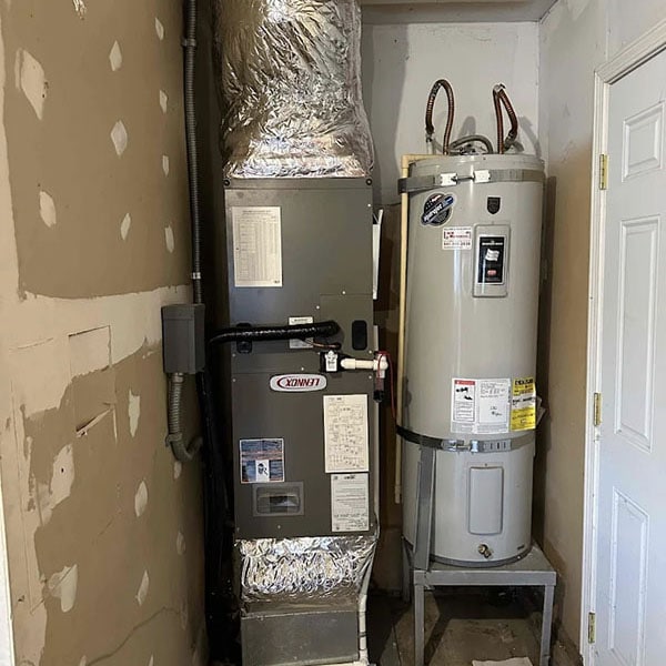 A tank water heater is next to an HVAC system in a home’s basement.