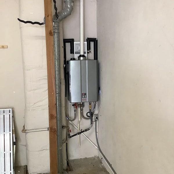 A newly installed tankless water heater in the basement of a home.